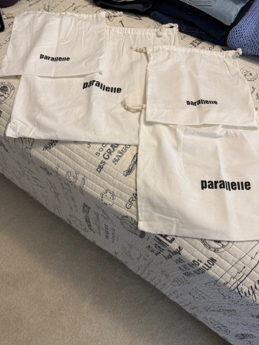 Parallelle set of 4 cotton drawstring bags.
